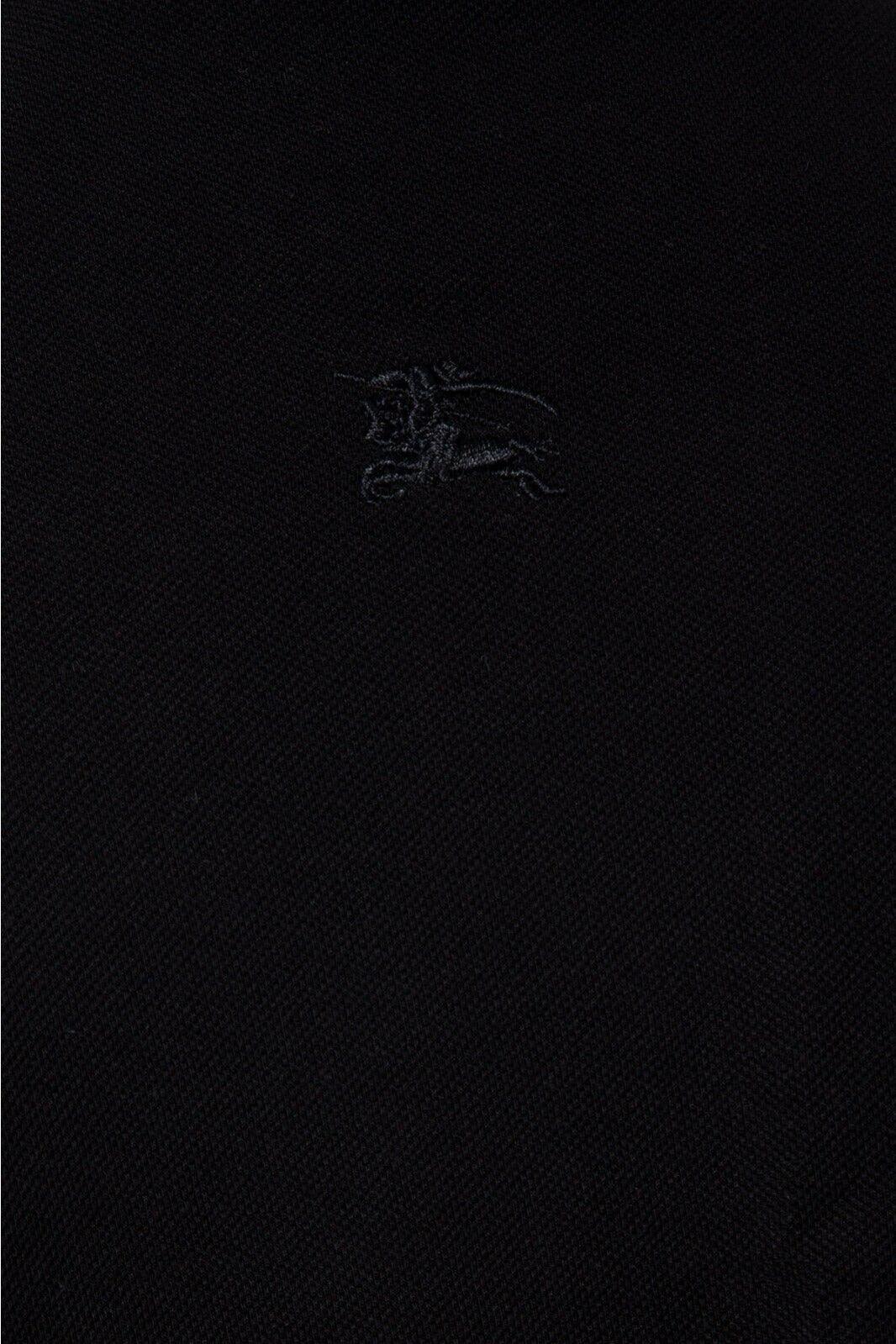 Close-up of black fabric with subtle embroidered lion logo detail